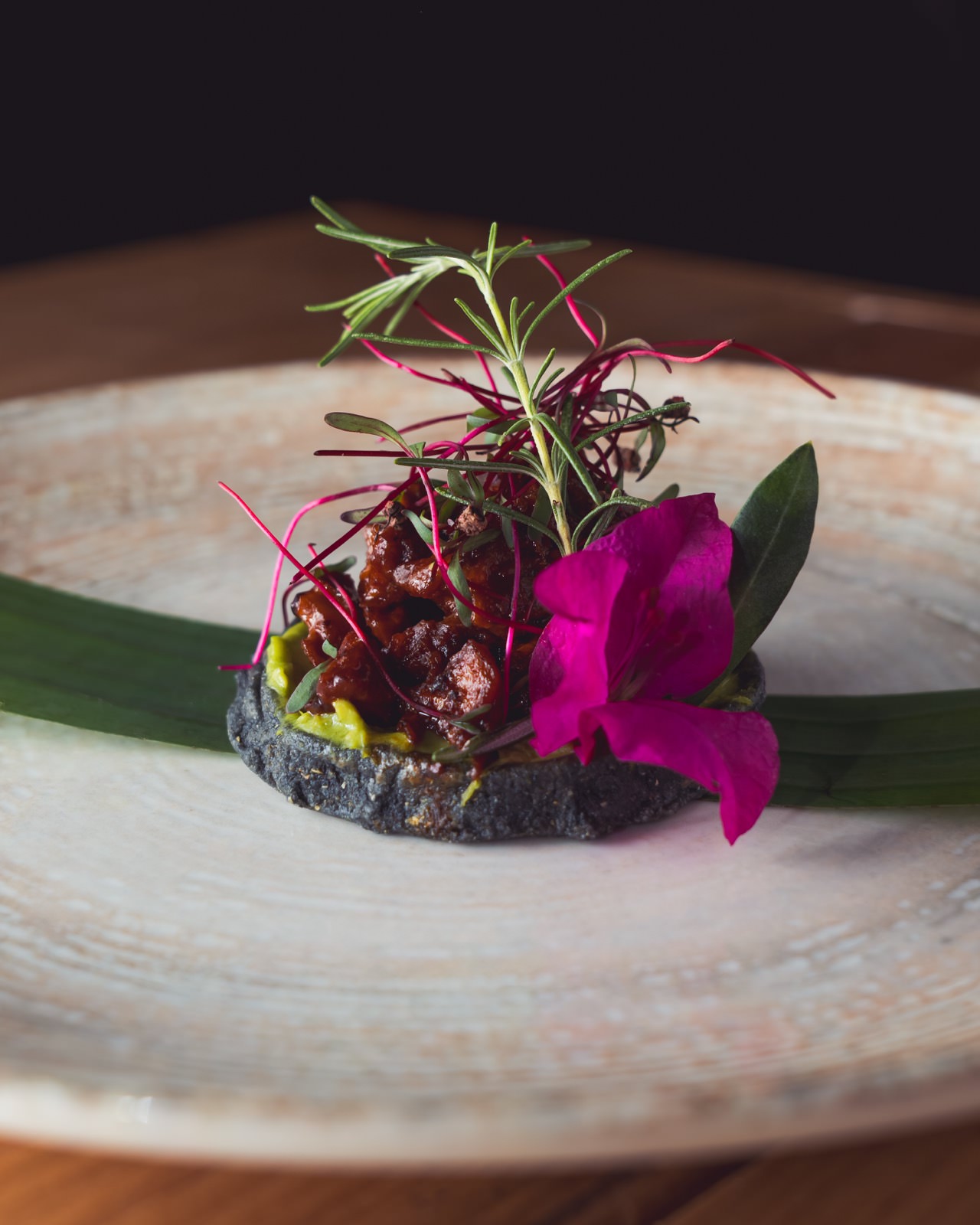 Plato gourmet con flores comestibles y decoración minimalista.